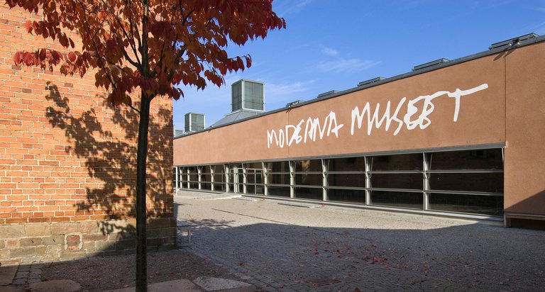 En lång brun byggnad med skylt "Moderna Museet".