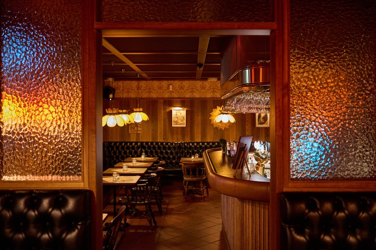 Restauranger i Stockholm. Rosetta's vid Hornstull. På bilden syns matsalen på restauranger. Träpaneler täcker väggarna och varmt ljus strömmar i lokalen.