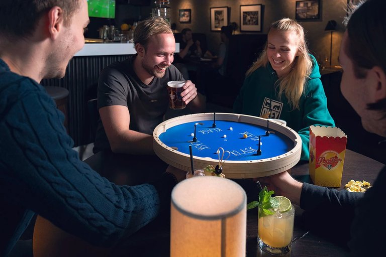 En grupp unga människor spelar sällskapsspelet Klask på Birka Bowling i Stockholm.