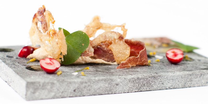 A fancy plate of food. Fresh herbs, thin crisps of cured meat and fresh vegetables. Stockholm is a great place to try out the latest trends in New Nordic Cuisine.